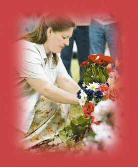 Patsy's daughter Julie Fudge placing flowers on Patsy's grave